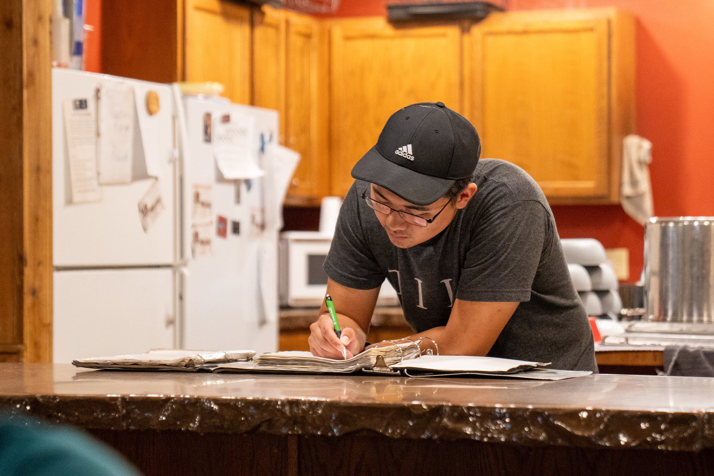 A Future Men student working through his coursework at the kitchen counter